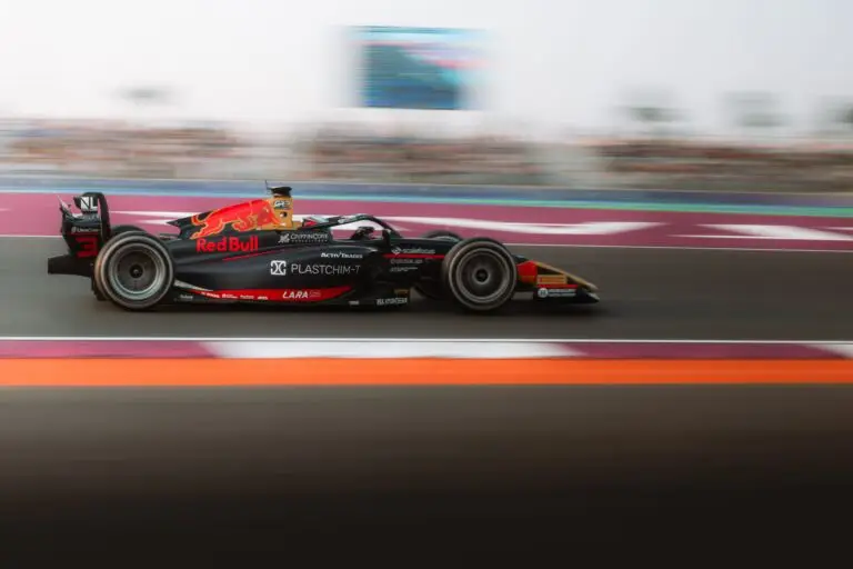 Carro fotografado com a técnica de panning: velocidade do obturador lenta mantém o carro nítido e transforma o fundo em linhas de movimento