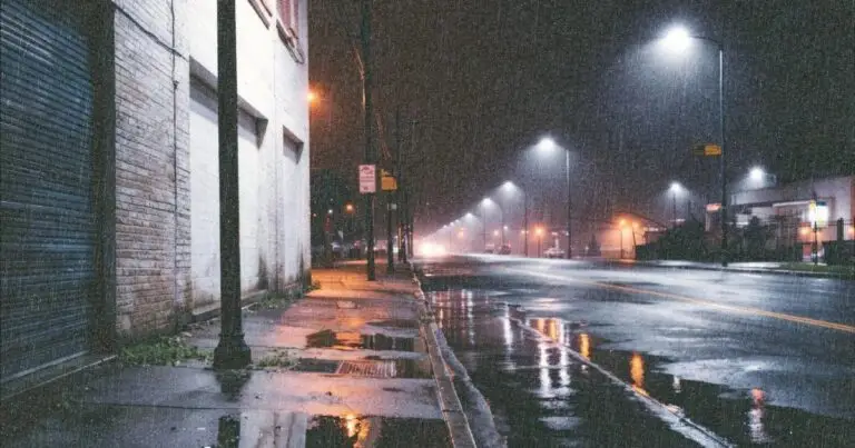 Rua urbana à noite com chuva e granulação visível, exemplo de foto com sensibilidade ISO alta em pouca luz